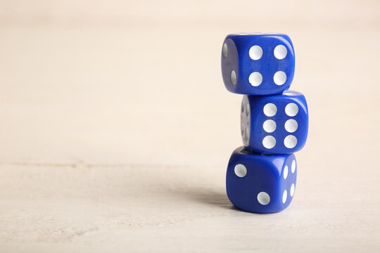 Blue game dices on white wooden background