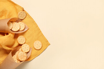Baking paper bundles with tasty crackers on beige background