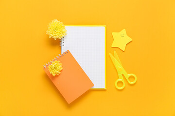 Obraz premium Notebooks, sticky notes and flowers on orange background