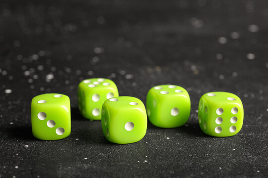 Green dices on dark background