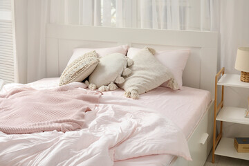 Interior of light bedroom with big comfortable bed near window