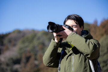 山で写真を撮る男性