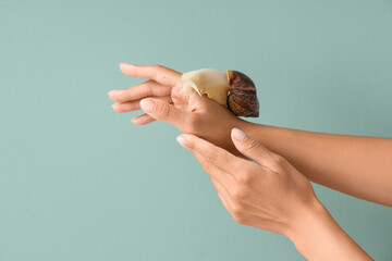 Female hands with snail on green background © Pixel-Shot
