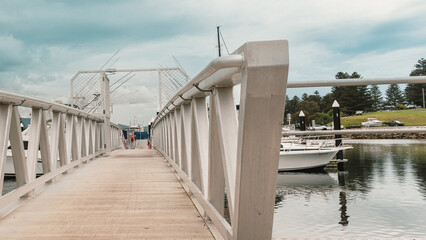 Fototapeta premium Visitors explore pier, coastal streets, and observe waterbirds at Bermagui Fishermen's Wharf, NSW, Australia, September 26, 2022