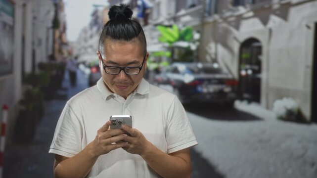 Man scrolling smartphone with hands visible on street wearing glasses and polo shirt; concentration digital connection.