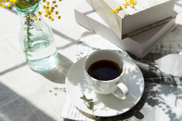 窓辺に置いたコーヒーとミモザの花
