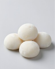 Four Glutinous Rice Cakes Stacked Elegantly on a Plain Background Highlighting Their Texture