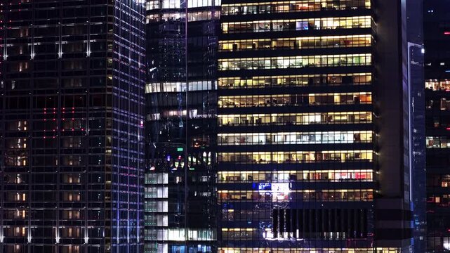 Futuristic Skyline At Night. Illuminated Hong Kong Cityscape Featuring Glowing Skyscrapers Rising Against Dark Evening Sky. Office Buildings of Financial District in Hong Kong Downtown. Glowing City