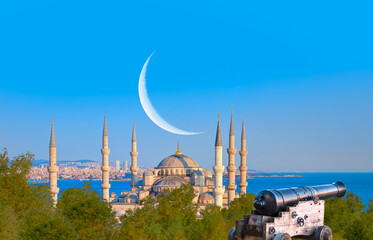 Ramadan Concept - Sultanahmet mosque and Bosphorus with crescent moon and cannon - Istanbul, Turkey