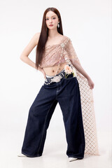 Modern trendy Thai fashion woman wearing a traditional Sabai paired with denim jeans, reflecting...