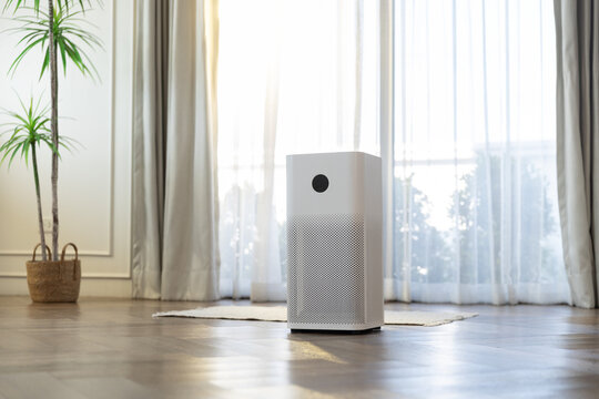 Air purifier in bright living room by large window, filtering dust and allergens for clean indoor air, healthy home environment, minimal interior design today.