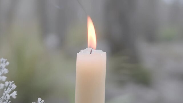 Close-up of a lit white candle with gentle smoke rising, symbolizing Imbolc and early spring traditions, with soft natural background and delicate lighting