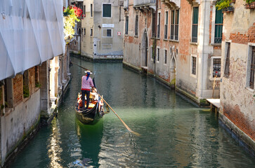 Italy, Venice, September 29, 2025,  A gondolier in a red and white striped shirt is transporting tourists in Venice © Pawel Filusz