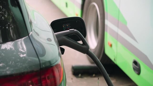 High power fast charging cable connected to BYD electric car in Shenzhen, China. Close-up of EV charging infrastructure supporting clean public transport and sustainable urban mobility.