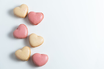 Obraz premium Heart Shaped Macarons Arranged on a White Background for Dessert Display or Decoration