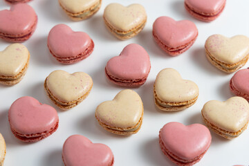 Obraz premium Heart Shaped Macarons on a White Surface With Various Colors and Flavors Laid out in a Pattern