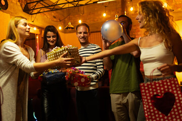 Fototapeta premium Group of Friends Exchanging Gifts and Celebrating at Indoor Party