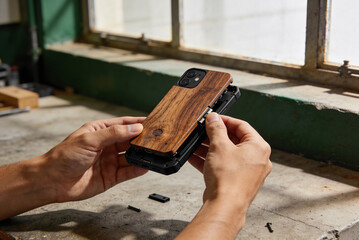 Designer hands assemble wood plastic modular smartphone case