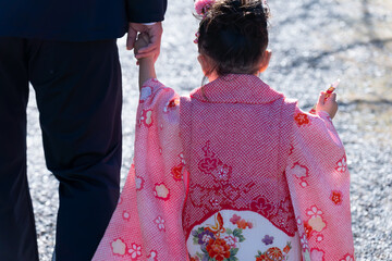 七五三のお祝いで手を繋ぐ親子の後ろ姿