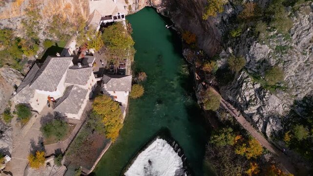 Epic aerial view of the historic Blagaj Tekke dervish monastery under a massive cliff, crystal clear source of the Buna river, Bosnia and Herzegovina, 4K