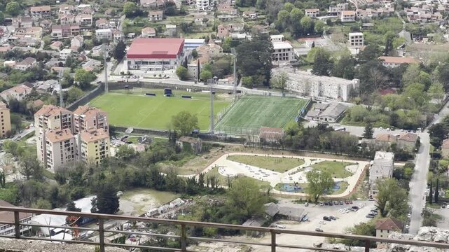 Elevated view of FK Bokelj football pitch in Kotor seen from Kotor Fortress with surrounding residential neighbourhood and greenery.