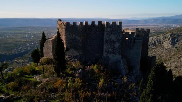 Epic medieval castle aerial orbit. 
Cinematic 4K drone continuous panorama 
with courtyard reveal of historic 
Stjepan Grad fortress in Blagaj, Bosnia.
