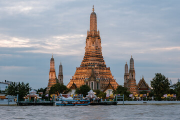 Naklejka premium Stunning sunset view of Wat Arun temple along the Chao Phraya River in Bangkok, Thailand