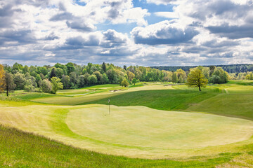 Obraz premium Golf green on a golf course with a beautiful view on a sunny spring day