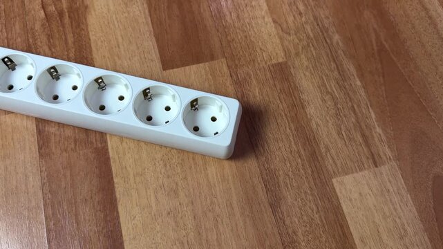 Two fingers in extension cord socket. Hand touches socket and receives powerful electric shock. The importance of electrical protection. The action that led to electric shock