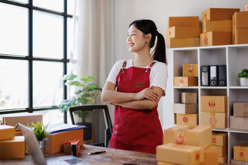 Cross arms, Smiling young Asian business owner woman standing arms crossed in office. Shopping Online concept.
