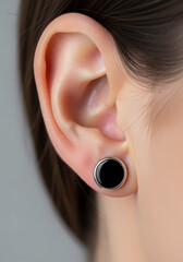 耳の拡大図、シンプルな黒色のイヤリング付き