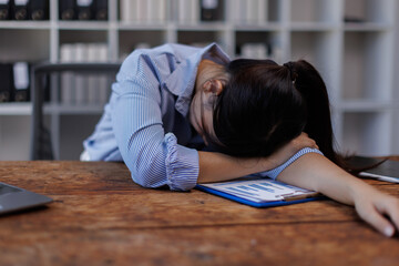 Obraz premium Businesswoman work financial documents is feeling stressed and having a headache while working late at her desk in the office, 