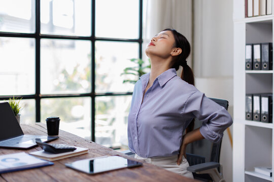 Body muscles stiff problem, ache asian young woman pain neck and shoulder while sitting work on chair at home, male holding massaging rubbing, hurt or sore body. Healthcare people, office syndrome.
