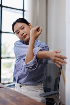 Body muscles stiff problem, ache asian young woman pain neck and shoulder while sitting work on chair at home, male holding massaging rubbing, hurt or sore body. Healthcare people, office syndrome.
