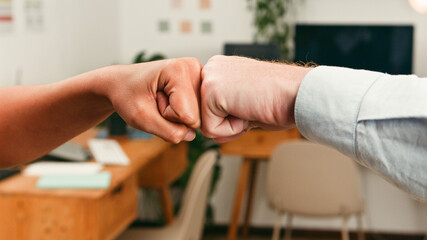 Obraz premium Fist Bump Between Colleagues in Office Symbolizing Teamwork and Collaboration