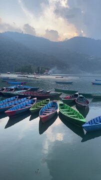 Group of local boats floating on the water at lake Phewa in Pokhara, Nepal. Phewa Lake is the second largest and most visited lake in Nepal.
