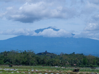 Aerial view of Borobudur Temple in Central Java, Indonesia, with Merapi volcano in the background. UNESCO World Heritage Site, culture, history, and travel themes © Wang