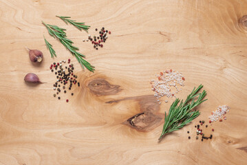 Rosemary, spices and garlic on wooden background, top view, flat lay, copy space, culinary background