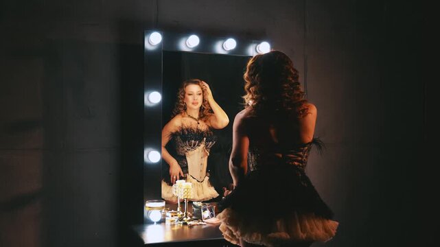 happy retro lady in short mini dress back rear view looking into mirror straightens blonde curly hair. sexy woman smiling face burlesque show. flapper girl dancer 20s roaring twenties. make-up table.