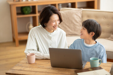 パソコンを見る男の子と横に座る母親