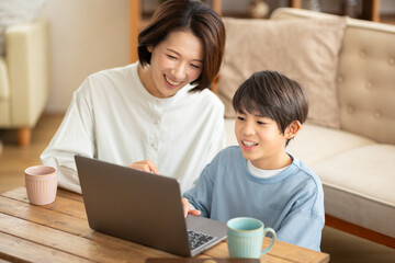 パソコンを見る男の子と横に座る母親