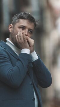 A man plays the harmonica on the street Against the background of a blurred street