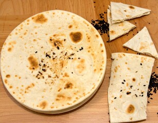 Golden flatbread, toasted dots, sprinkled with seeds