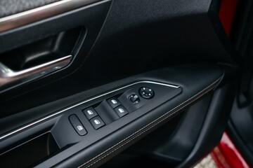 Interior details. Modern black car interior, leather steering wheel, climate control, large navigation system screen.