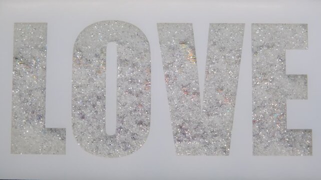 a set of decorative letters for the wall or mirror in the shape of LOVE featuring a diamond pattern made of crushed crystal or glitter with dark background