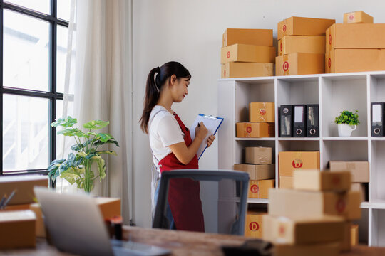 Smart Asian millennial female online business owner checking hier sme product stocks in the stock room. SME startup business entrepreneur.
