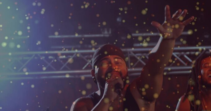 Falling golden confetti, camera zooming to lead vocalist engaging crowd with wired mic, music