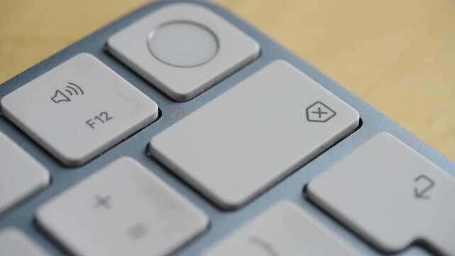 Close up shot of a person repeatedly pressing the backspace button on a sleek computer keyboard. Ideal for concepts of editing, correcting mistakes, and data deletion.