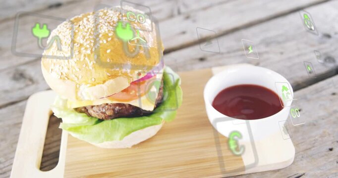 Sesame burger sitting while green icons appearing top-right drifting, rotating, showing eco impact