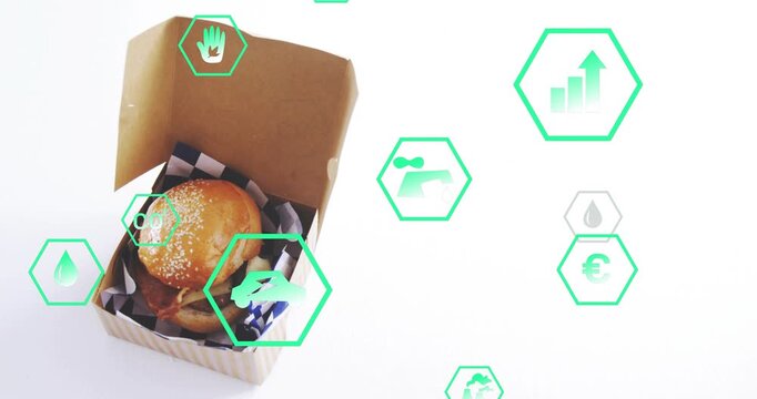 Sesame burger sitting in box, green hex icons emerging right, drifting showing eco metrics